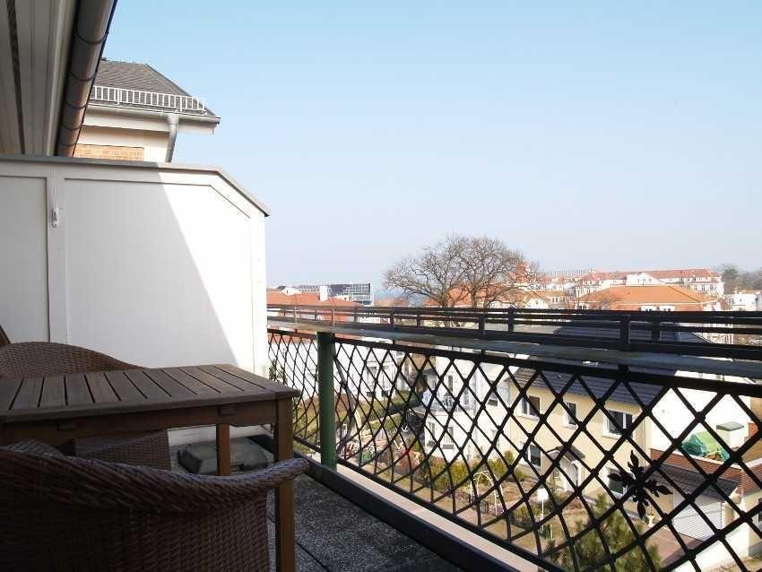 Terrasse mit Tisch und Stühlen, Blick auf Wohngebiet und Gebäude