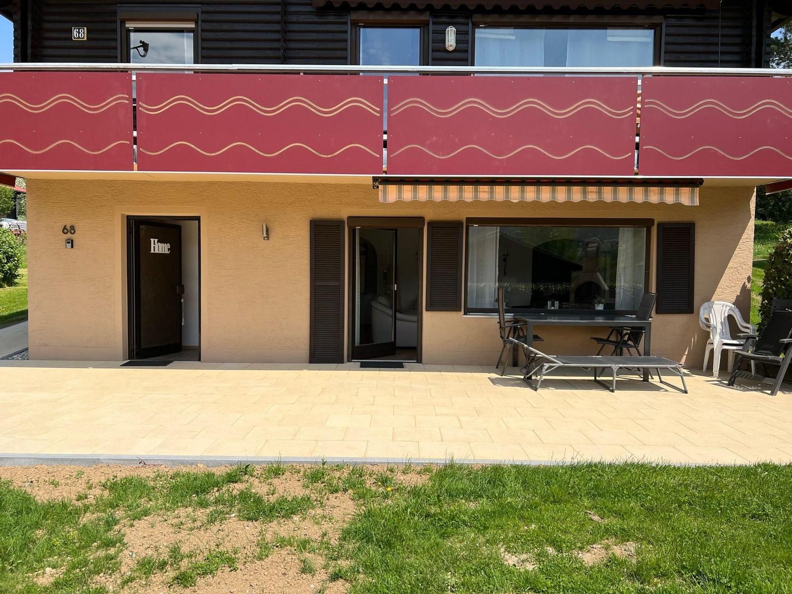 Villa with terrace, grill area, and balcony with red railings.