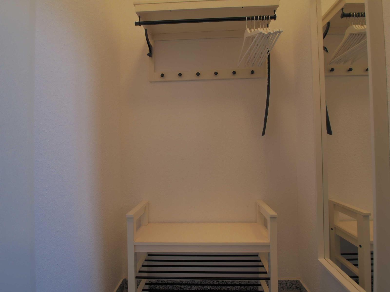 Kleiderständer mit Haken und Stuhl im Schrank