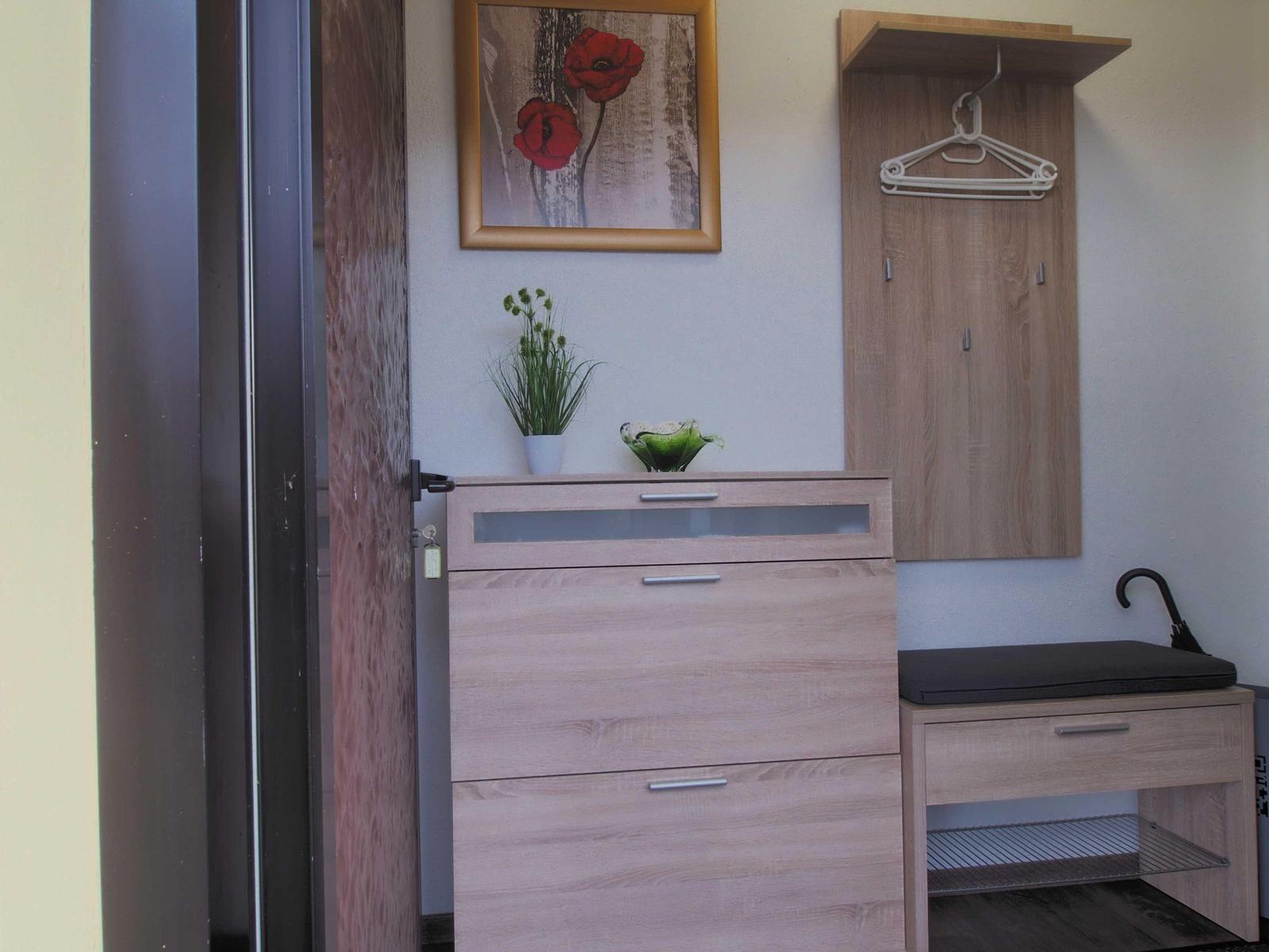 Entrance area with shoe cabinet, coat hanger, and plants.
