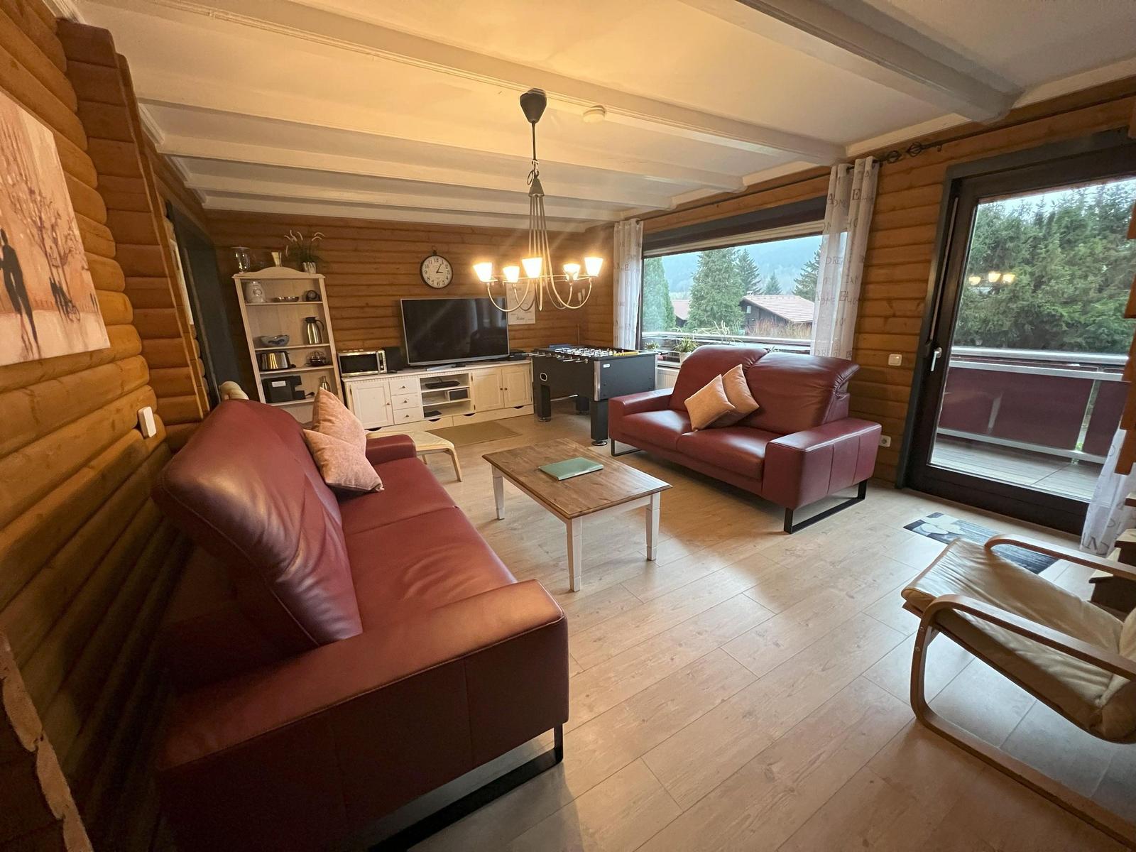 Living room with red sofa, TV, and view of balcony