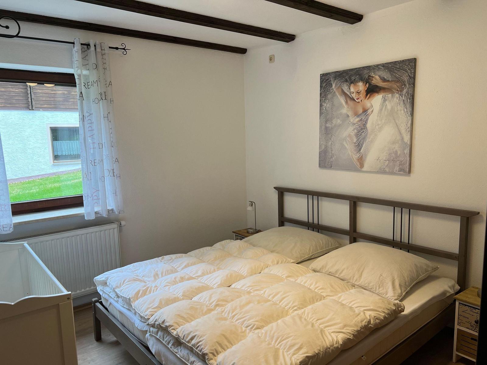 Bedroom with bed, window, and wall art.