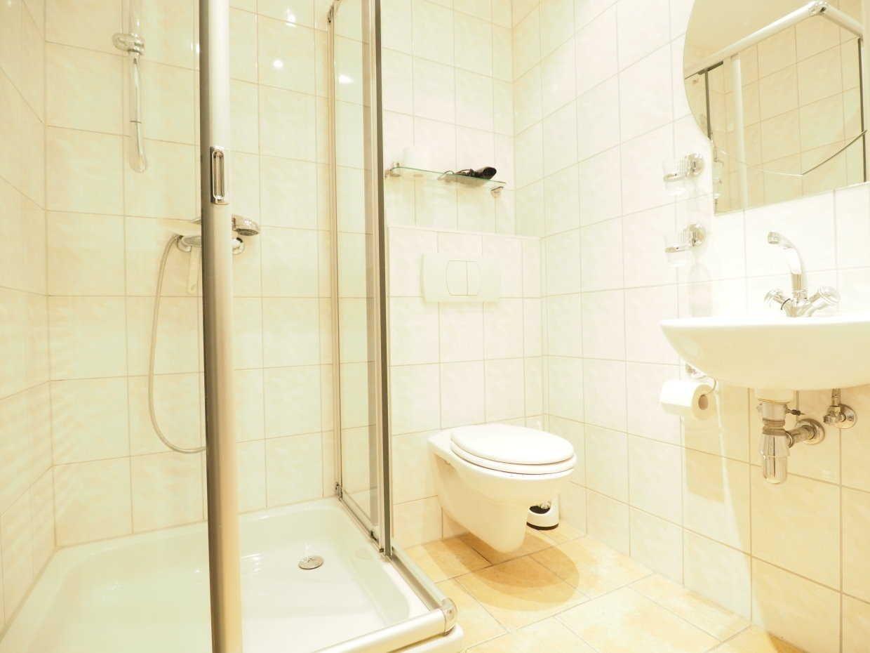 Badezimmer mit Dusche, Toilette und Waschbecken.