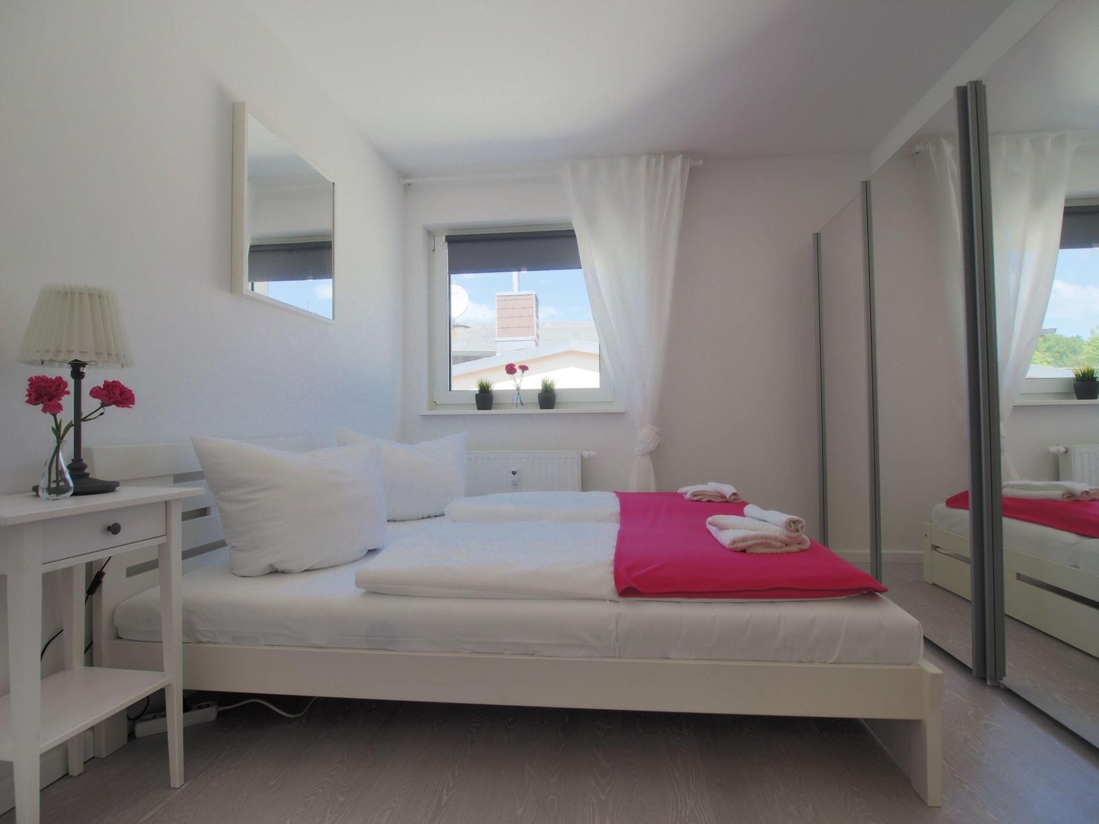 Schlafzimmer mit Doppelbett und großem Kleiderschrank