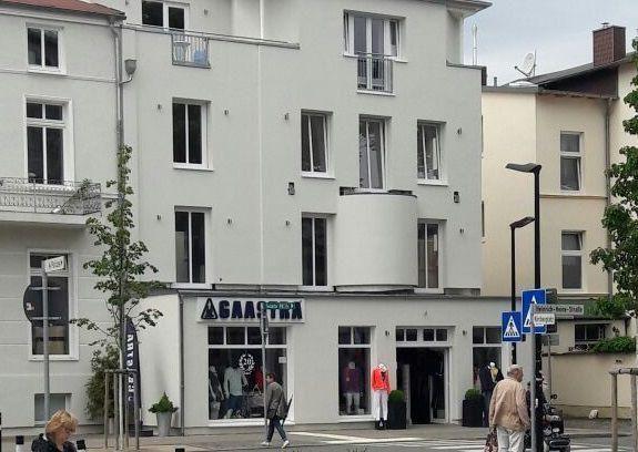 Fassade eines mehrstöckigen Gebäudes mit Geschäft und Eingang