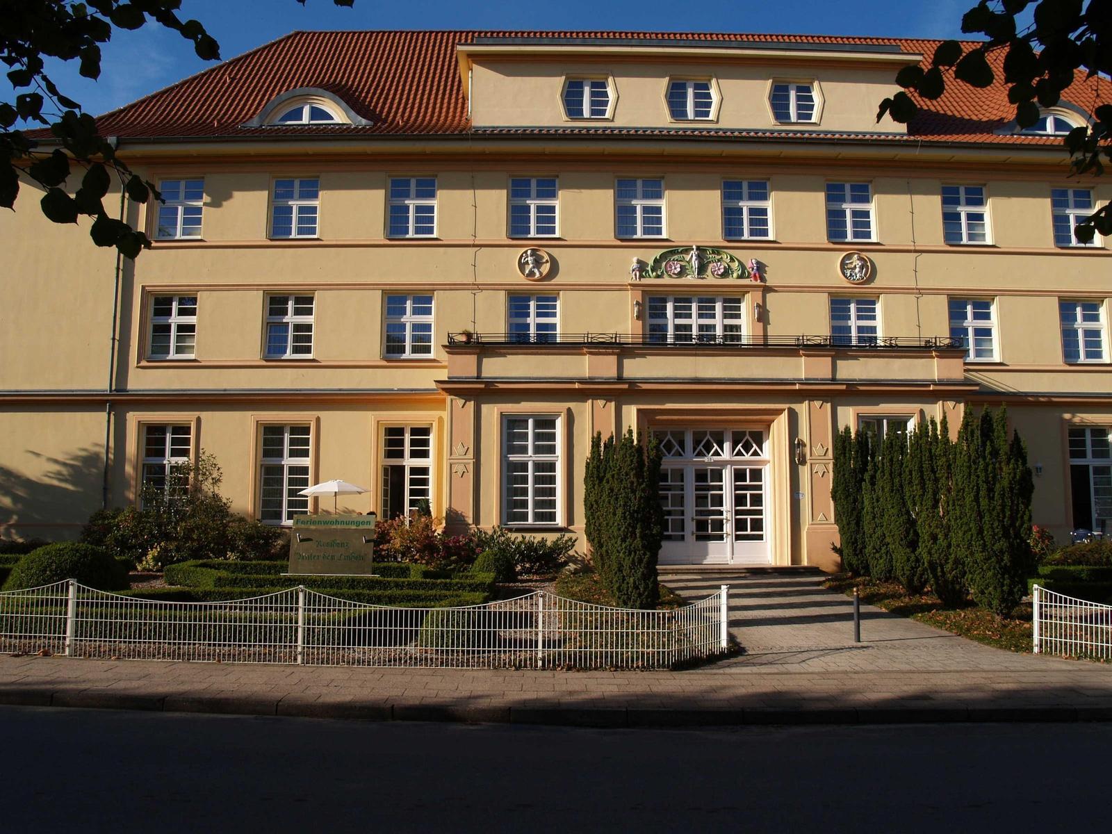 Ferienwohnung Residenz Unter den Linden mit Eingang, Fenstern und gepflegtem Garten.