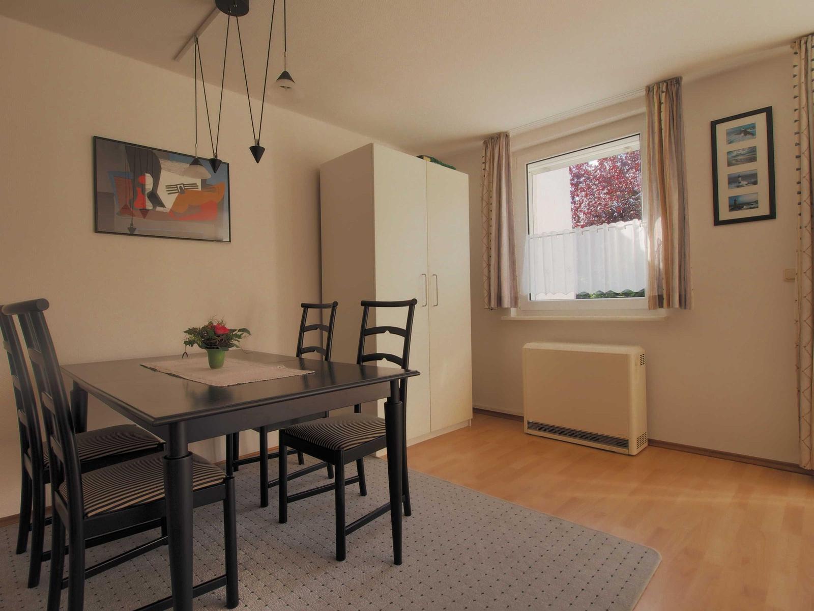 Esszimmer mit Tisch, Stühlen, Kleiderschrank und Fenster mit Blick.