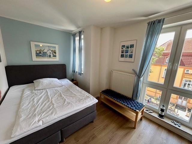 Schlafzimmer mit Doppelbett, Fenster und Holzboden