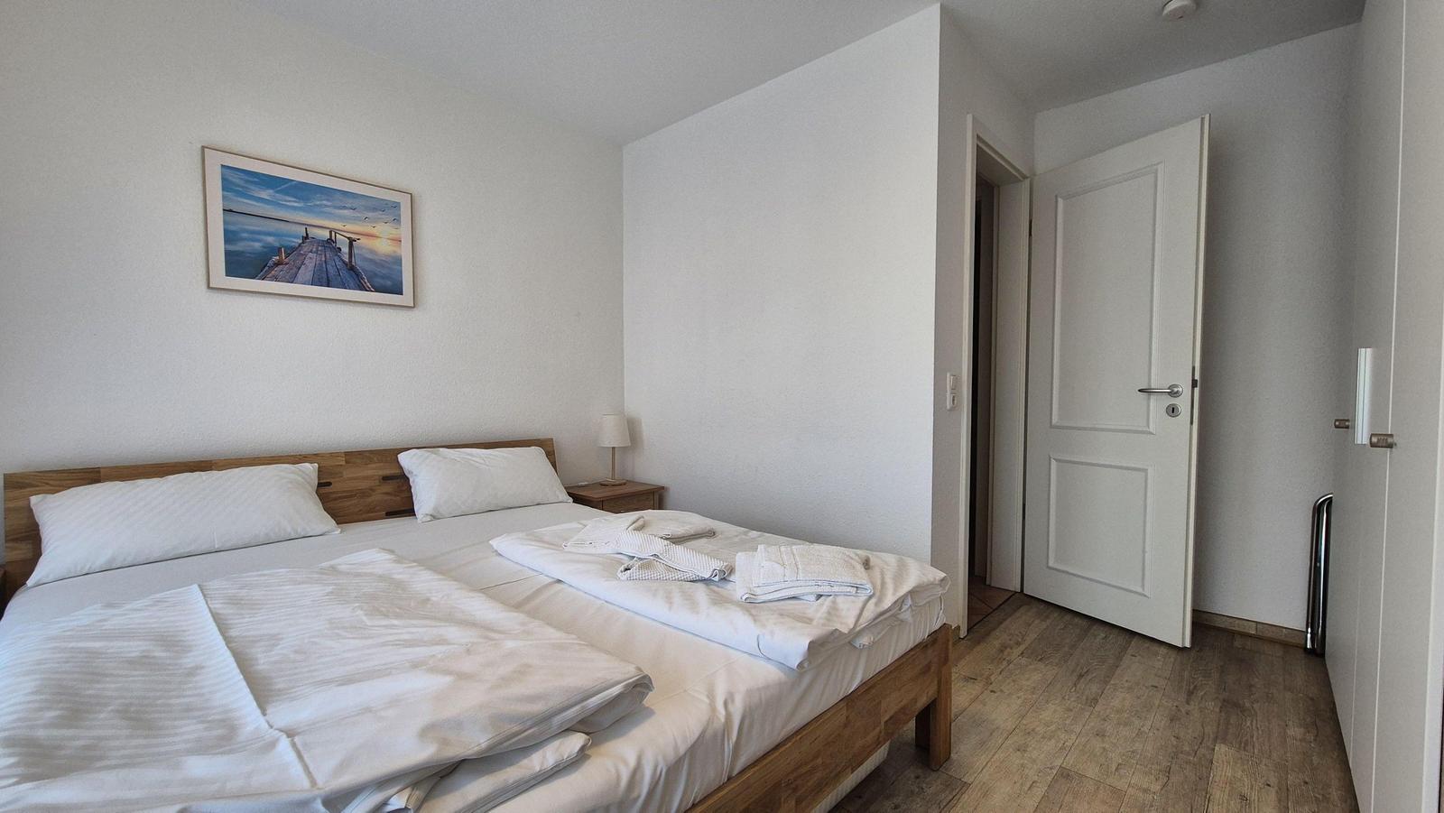 Ein Schlafzimmer mit einem Bett, einem Nachttisch und einer Tür.
