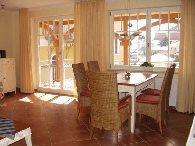 Esszimmer mit Tisch, Stühlen und Blick auf Balkon und Straße