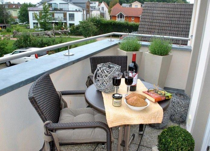 Balkon mit Tisch, Stühlen und Blick auf Wohngebiet.