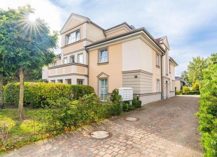 Einfamilienhaus mit gepflastertem Weg und grüner Umgebung.