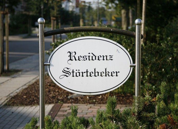 Schild mit der Aufschrift Residenz Störtebeker in einem Gartenbereich.