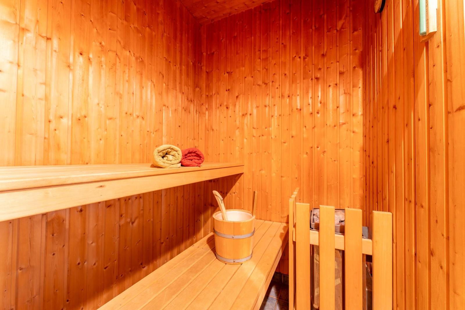 Holzsauna mit Bank, Eimer und Handtuch