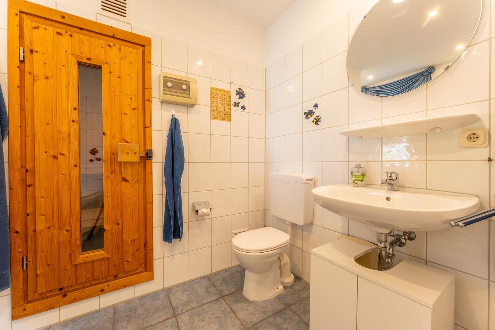 Badezimmer mit Dusche, Toilette und Waschbecken.