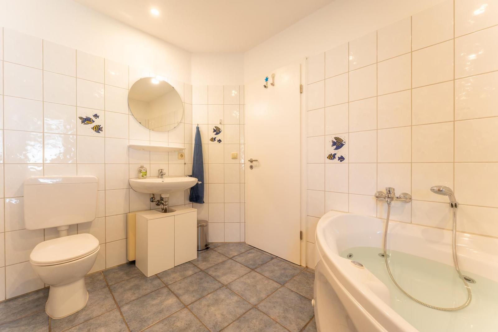 Badezimmer mit Badewanne, Toilette und Waschbecken.