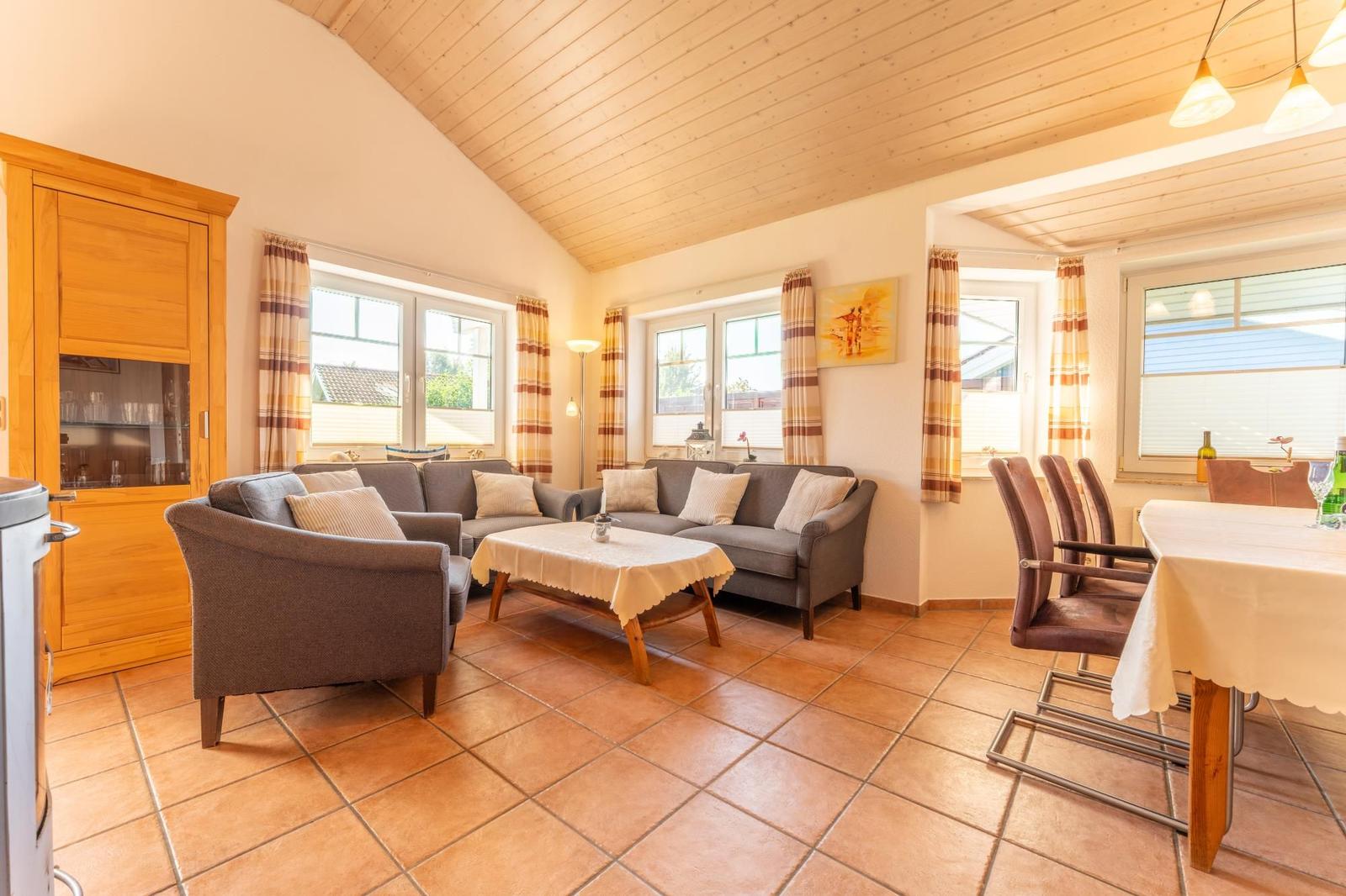 Wohn- und Essbereich mit Sofa, Sessel, Tisch und Küchenzeile.