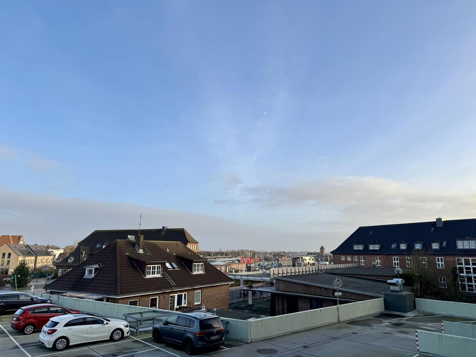 Rooftop-Parkplatz mit Blick auf Gebäude und Himmel mit Mond.