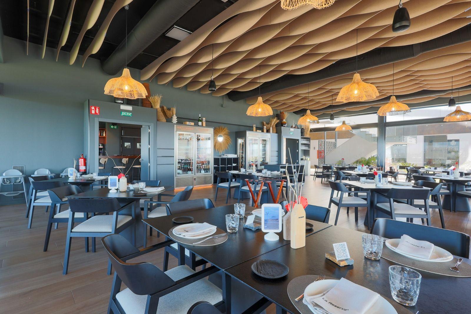 Modern dining room with tables, chairs, and ceiling lights.