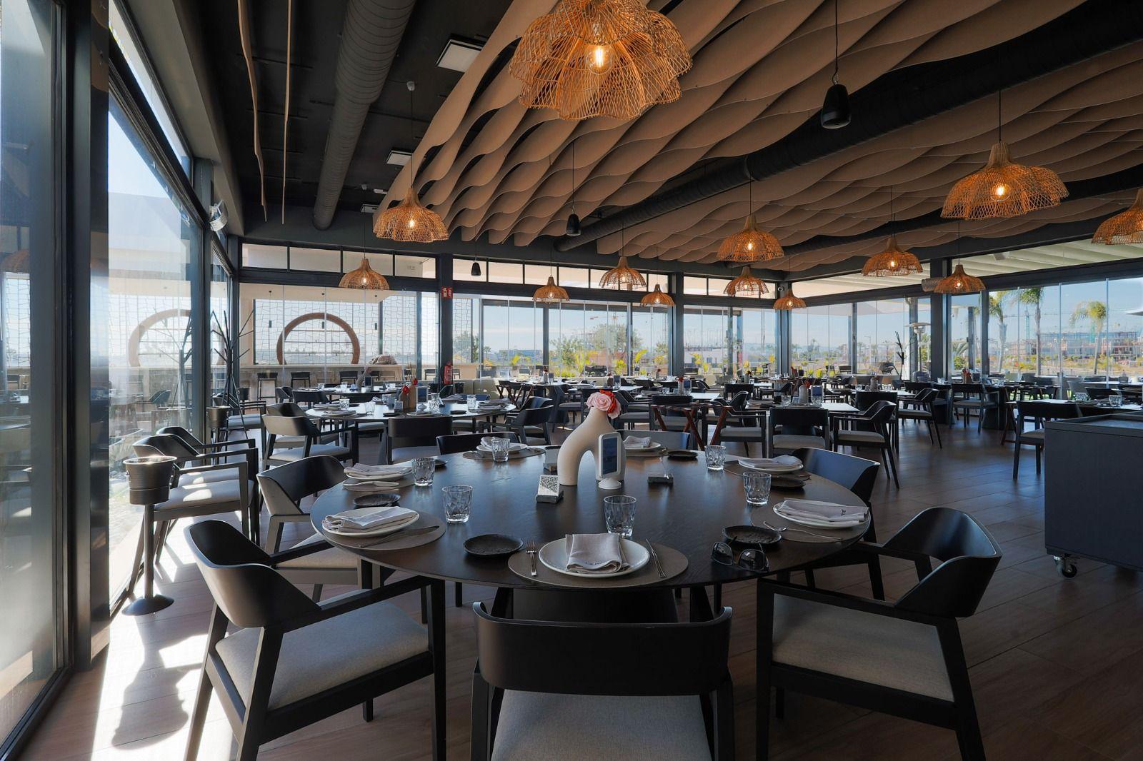 Large dining room with tables, chairs, and large windows.