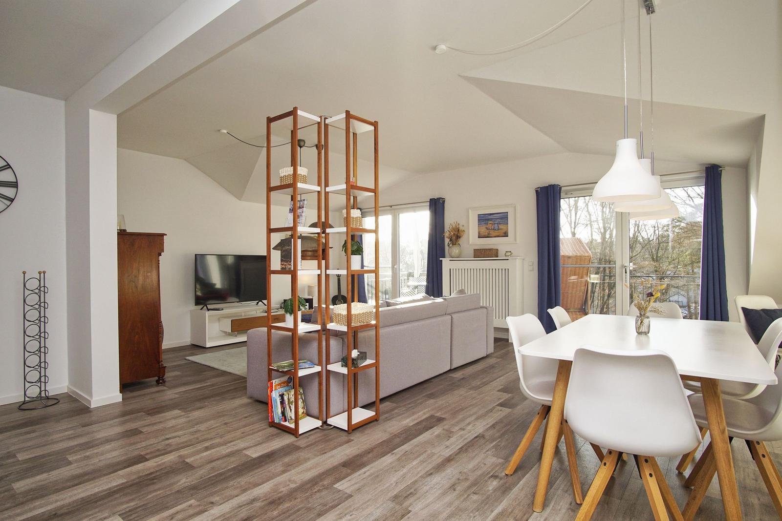 Wohn- und Essbereich mit Sofa, TV und Esstisch mit Stühlen.