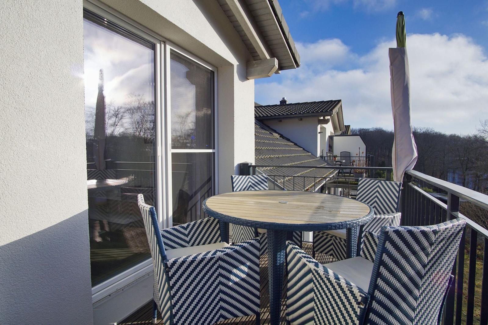 Terrasse mit runden Tisch und vier Stühlen mit schwarz-weißem Muster.