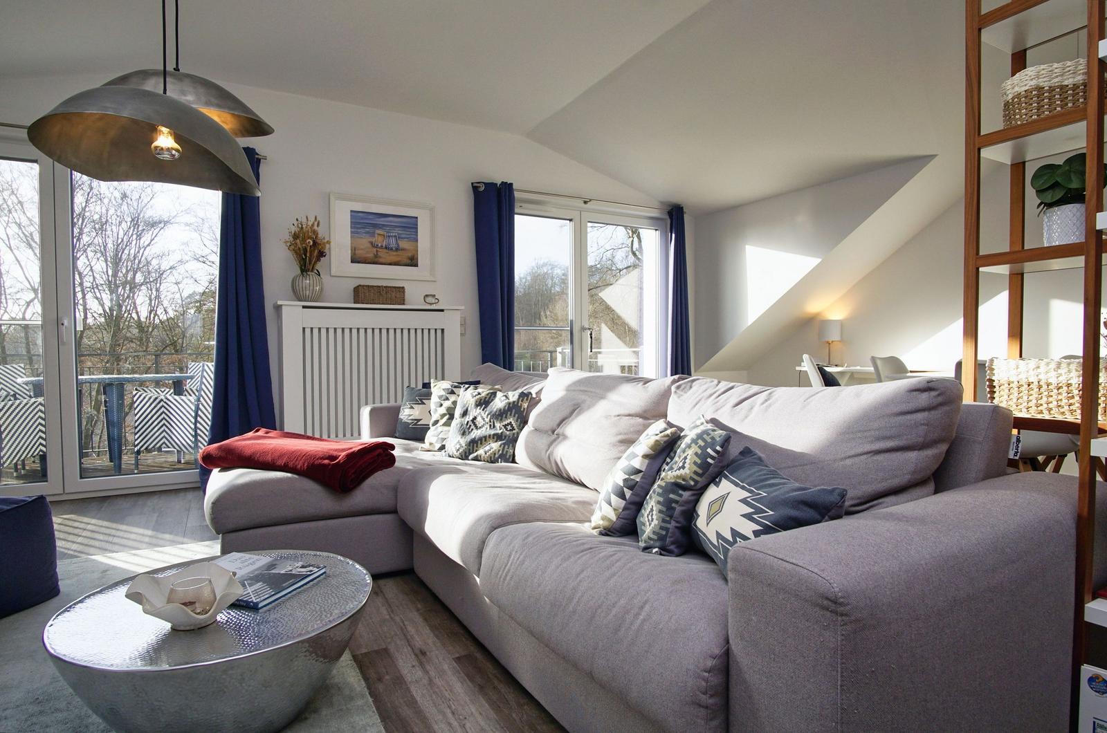 Wohnzimmer mit Sofa, Couchtisch und Blick auf Balkon