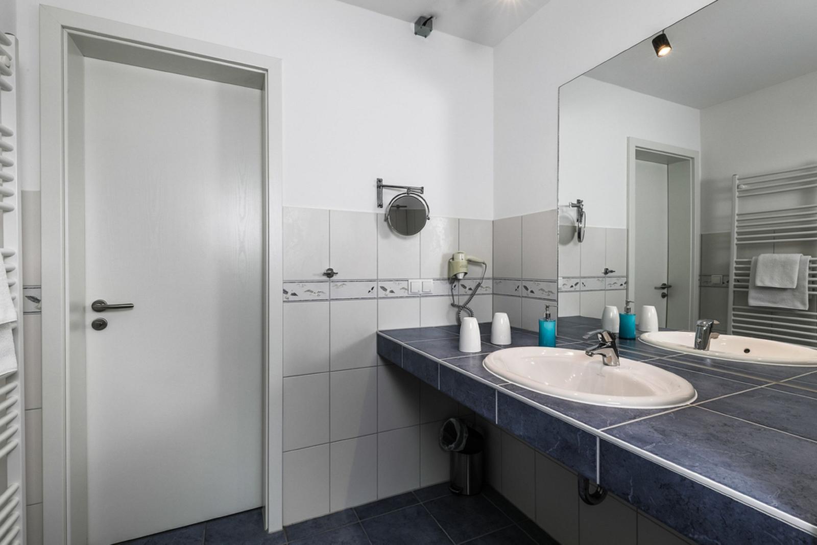 Badezimmer mit Waschbecken, Spiegel und Handtuchhalter