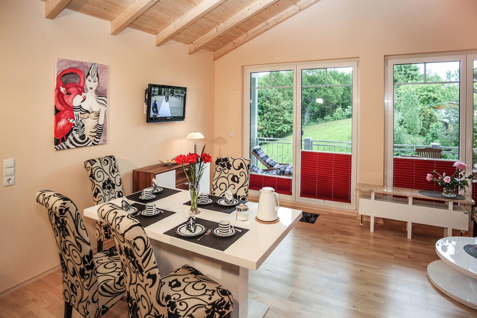 Esszimmer mit Tisch, Stühlen und Blick auf Balkon