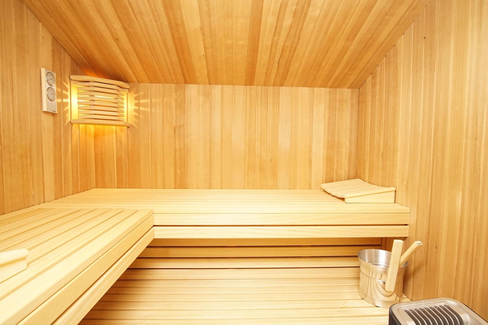 Sauna mit Holzbank, Thermostat und Badekessel.