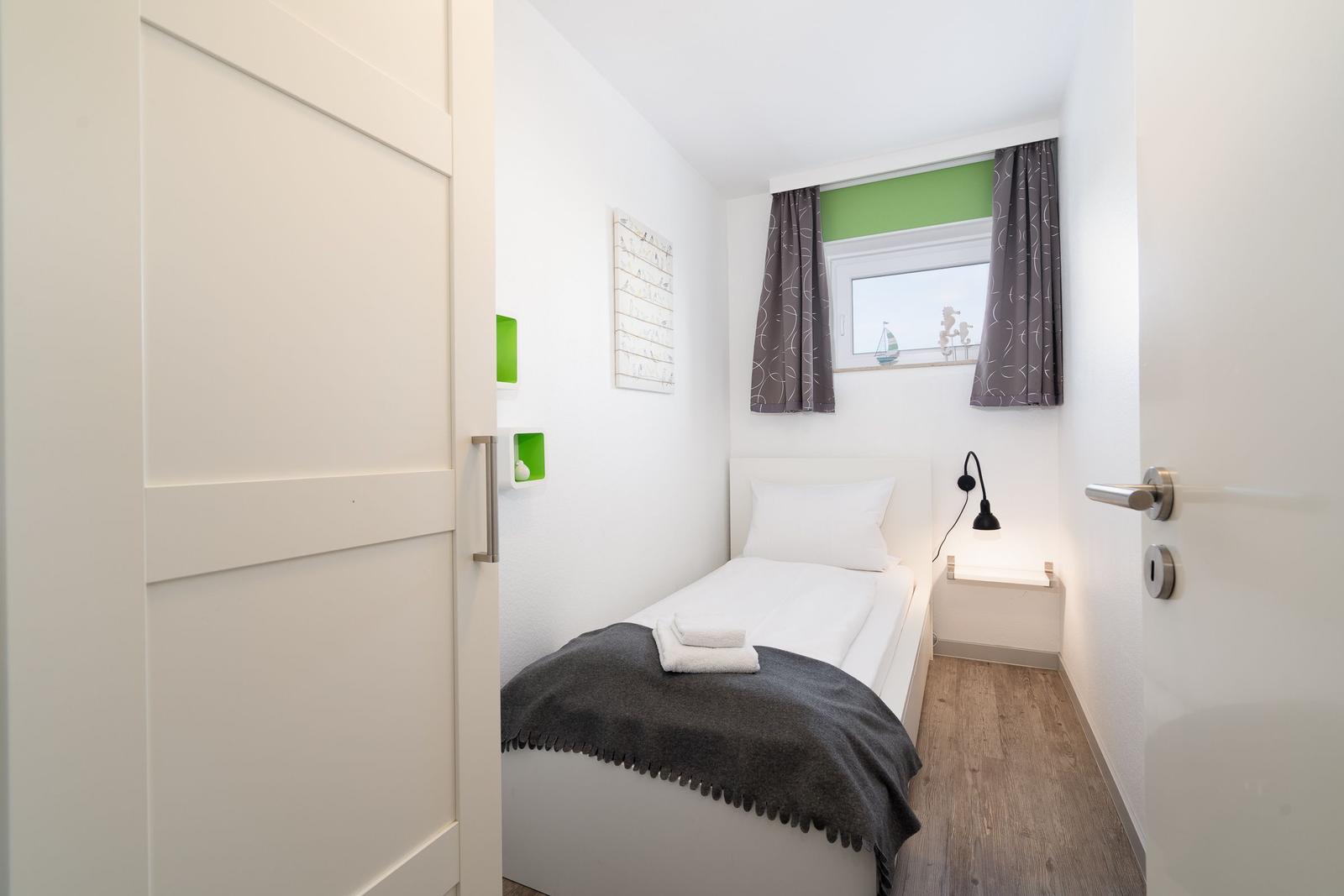 Ein Schlafzimmer mit einem Bett, einem Fenster und einer Tür.