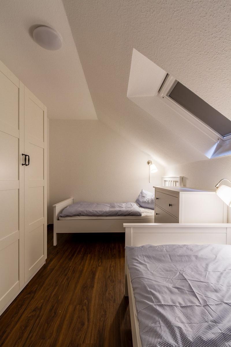 Zwei Betten, Schrank und Dachschräge mit Dachfenster.