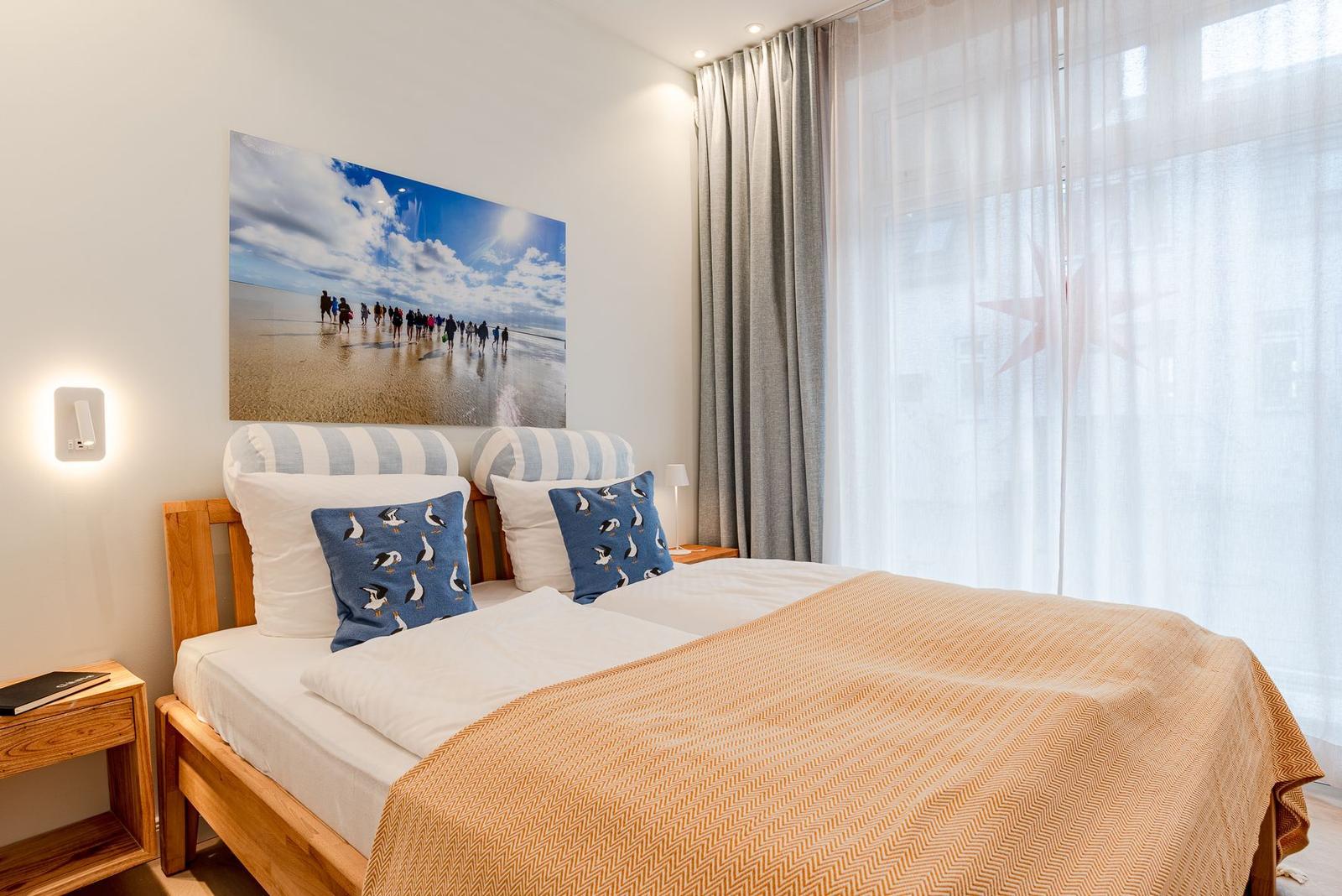 Ein Schlafzimmer mit einem Bett, zwei Kissen und einer Wanddekoration.