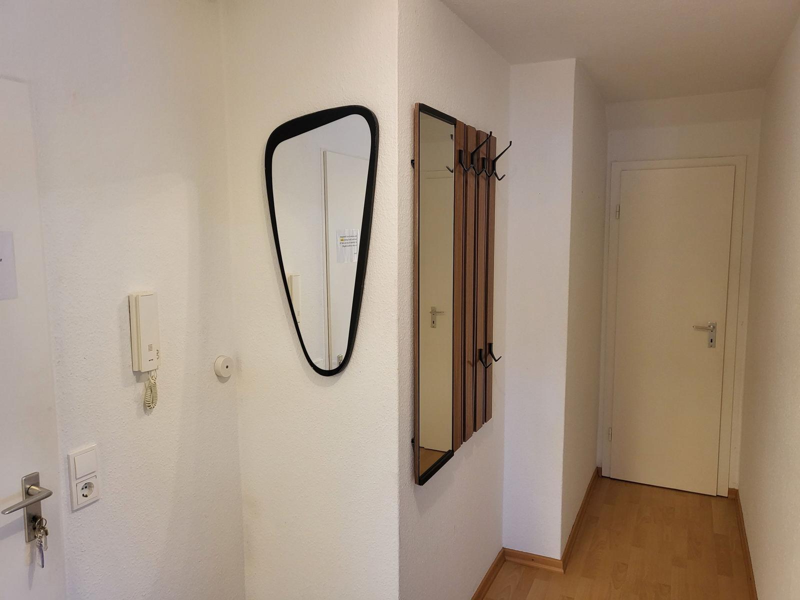 Eingangsbereich mit Spiegel, Garderobe und Tür