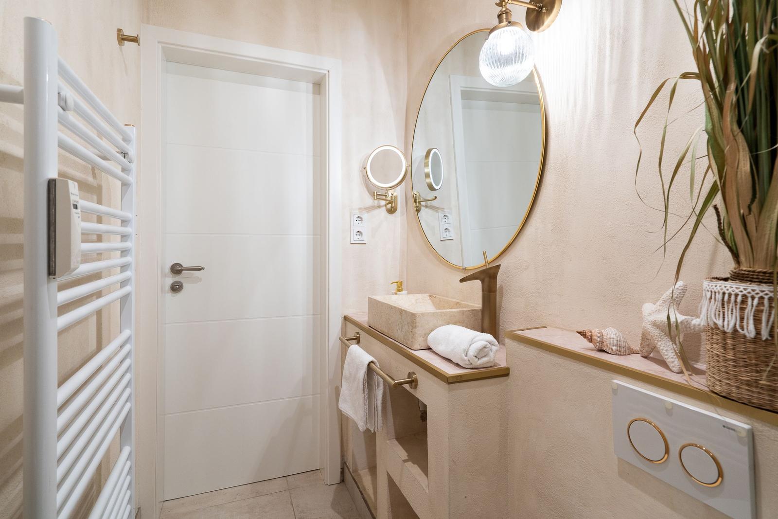 Badezimmer mit Waschtisch, Spiegel und Heizkörper