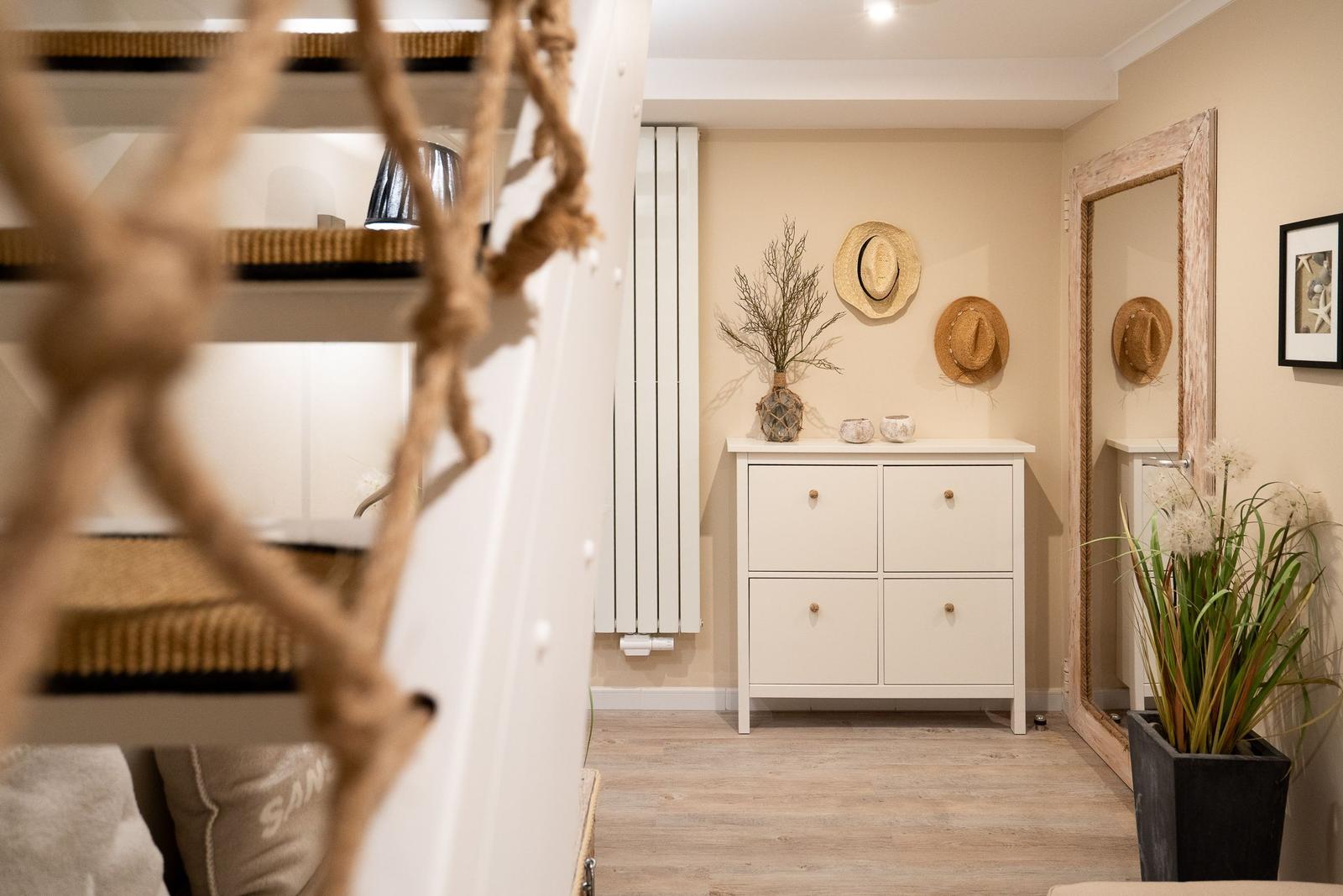 Eingangsbereich mit Schrank, Spiegel und dekorativen Hut an Wand