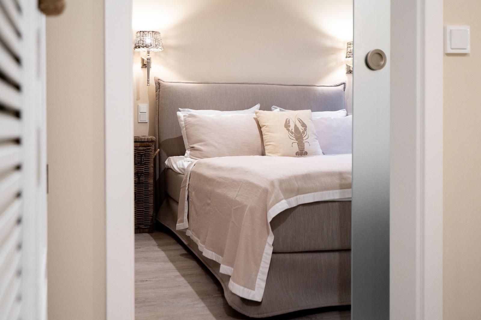 Schlafzimmer mit Bett, Kissen und Wandlampen