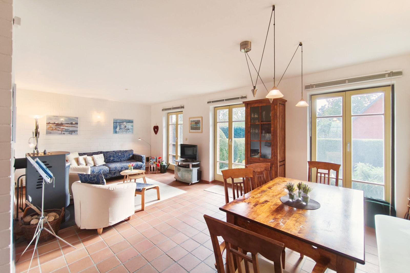 Wohn- und Essbereich mit Holztisch, Sofa und Terrassentür.