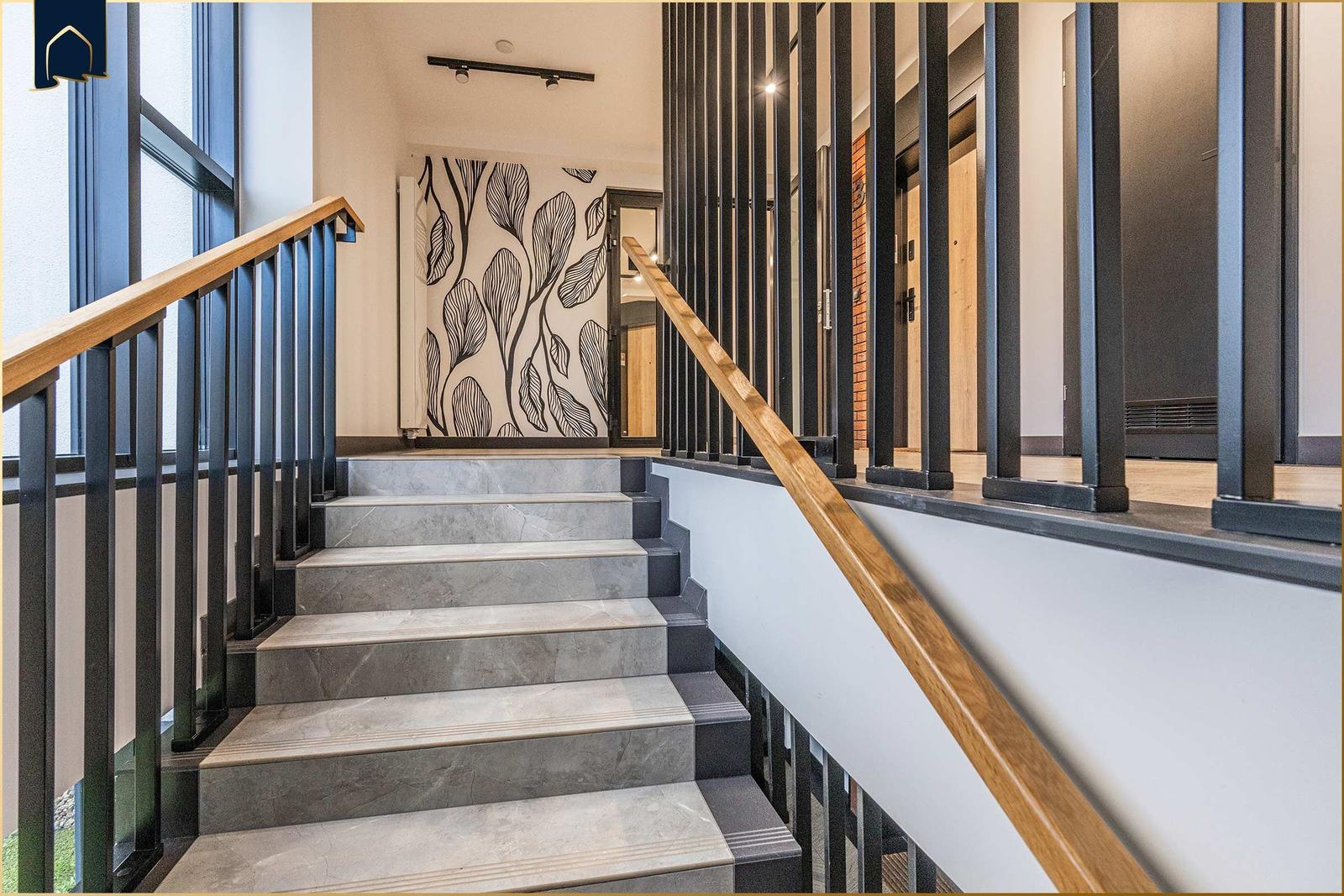 Haus mit moderner Treppe und Holzgeländer. Wandbild mit Blattmotiv.