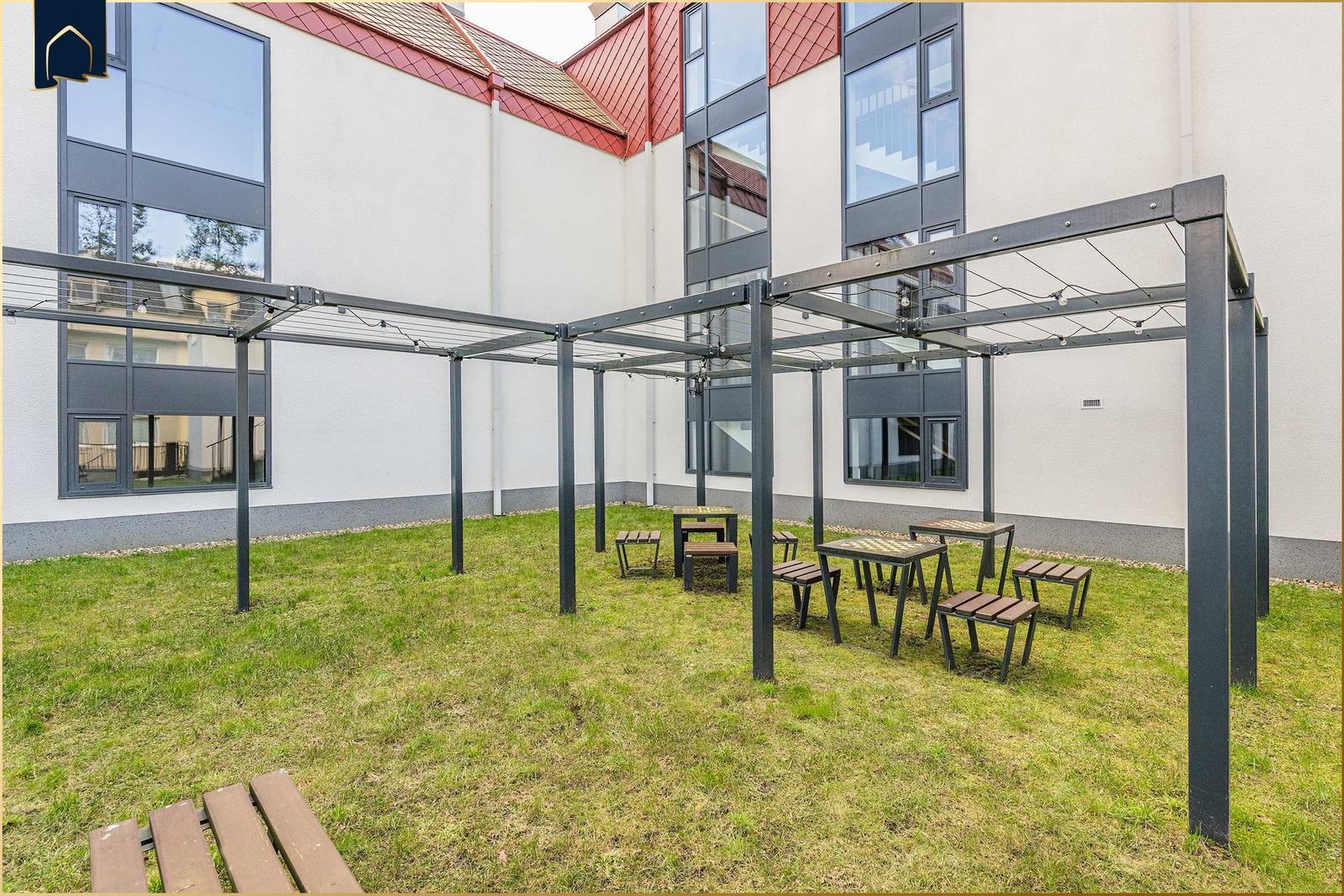 Hinterhof mit Pavillon, Tischen und Bänken auf Rasenfläche