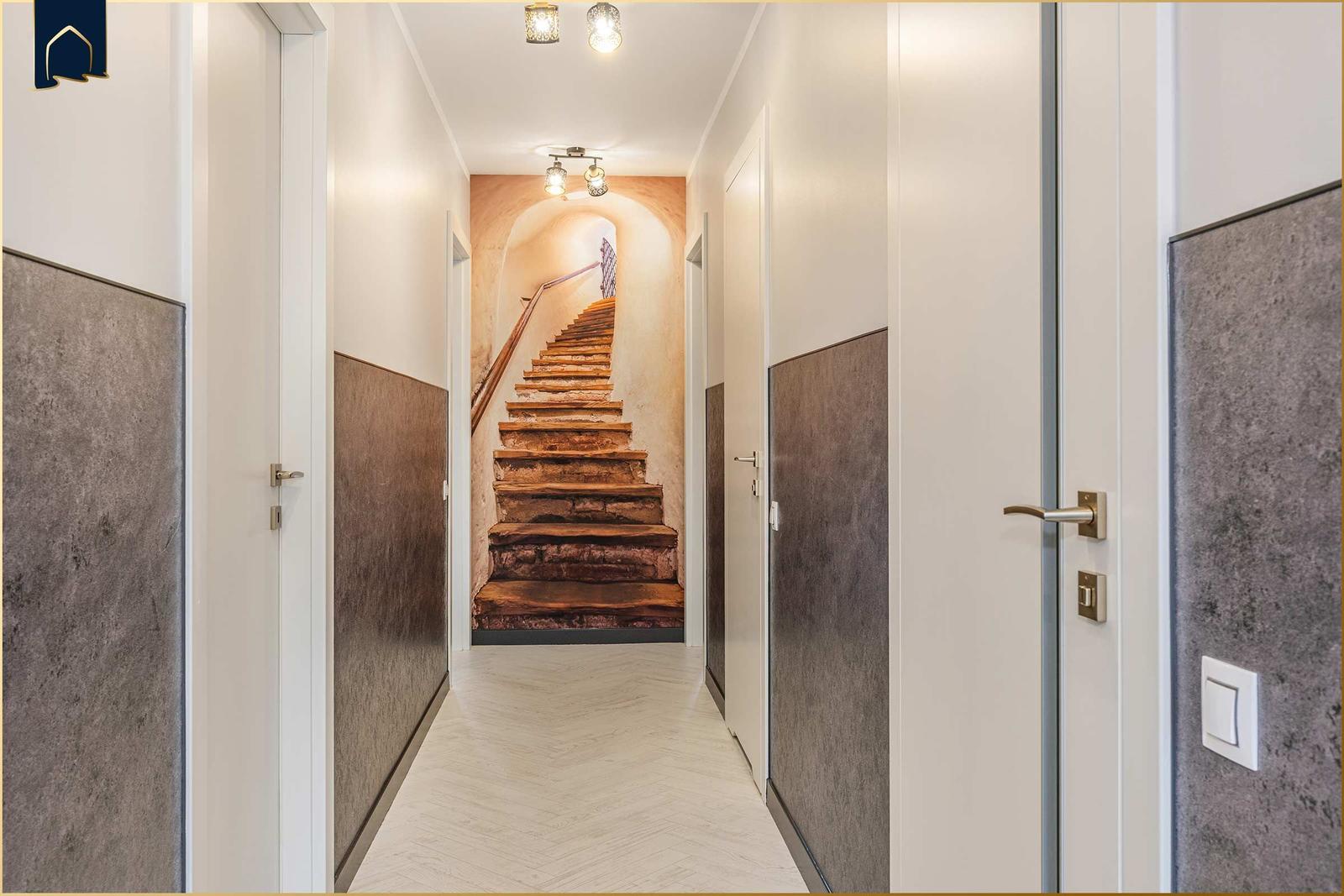 Flur mit Treppe und Türen. Wandverkleidung und Herringbone-Boden.