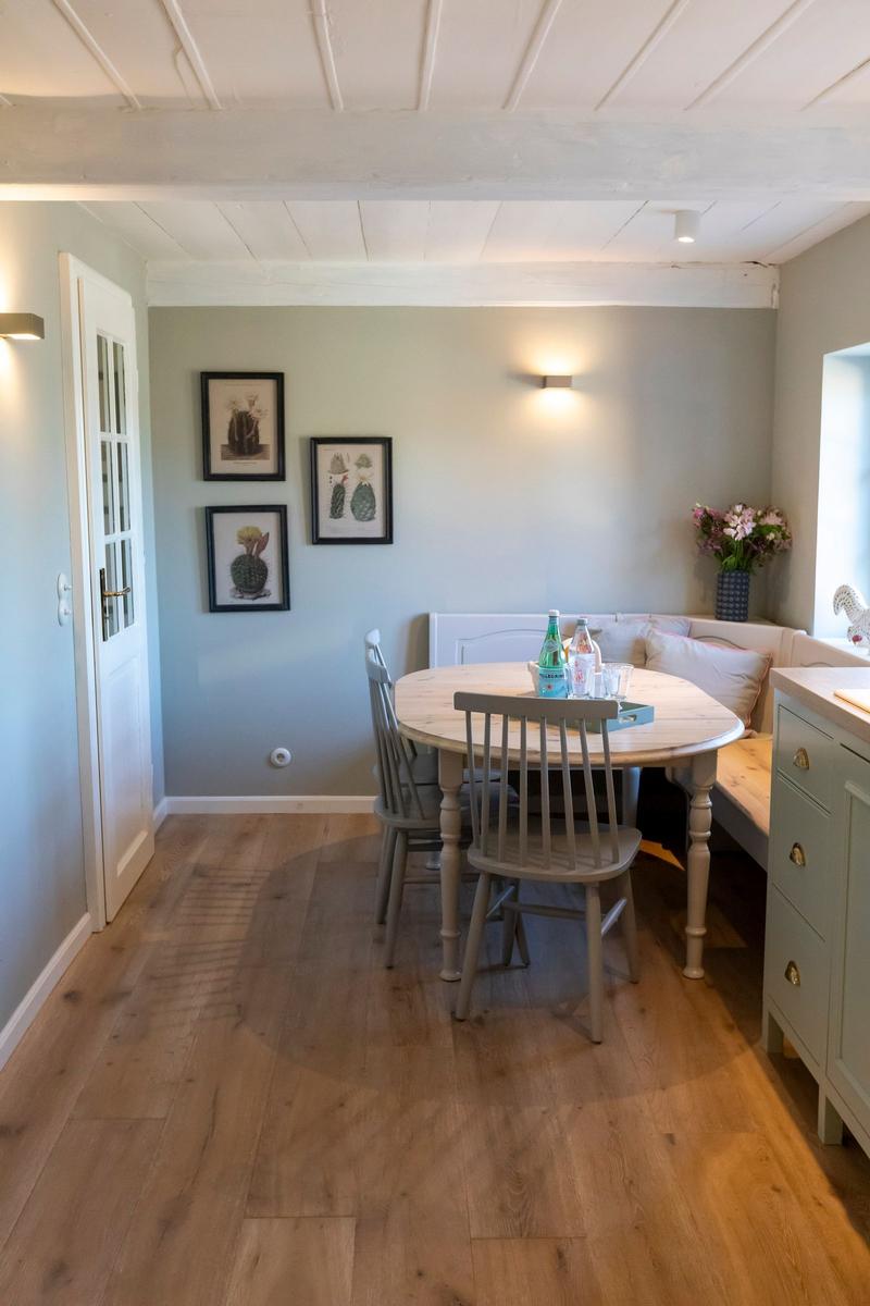 Esszimmer mit runden Tisch, Sitzbank und Wandbildern