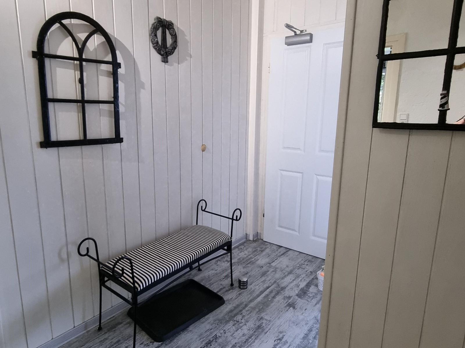 Entrance area with bench, wall decor, and door.