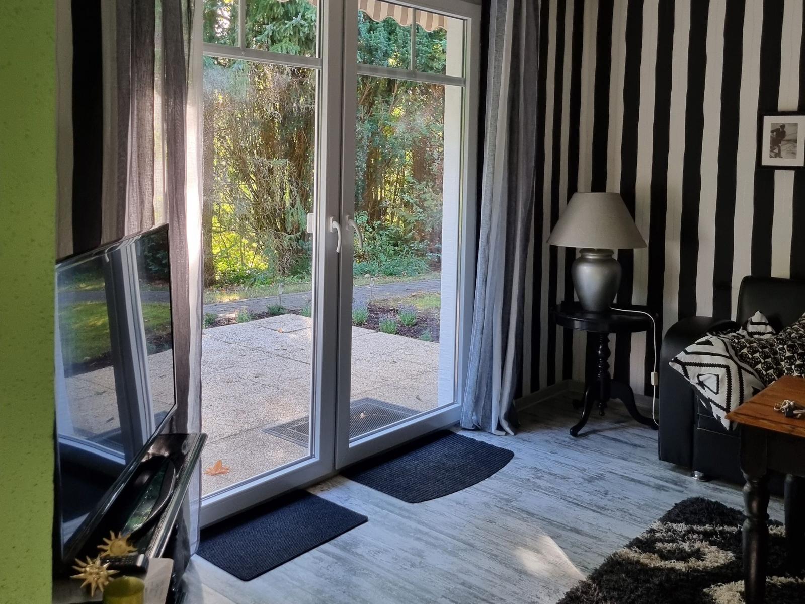 A room with black-and-white striped wall, sliding door, and TV.