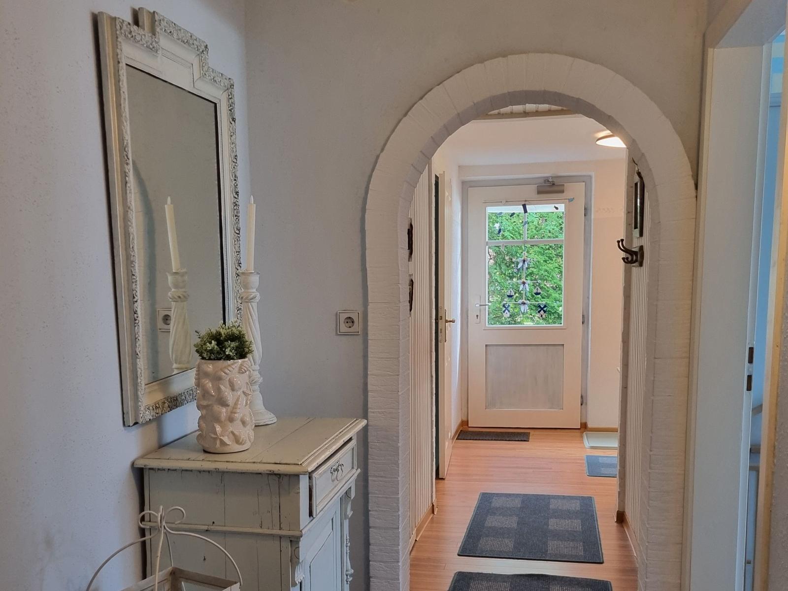 Entrance area with mirror, cabinet, and arch to the door
