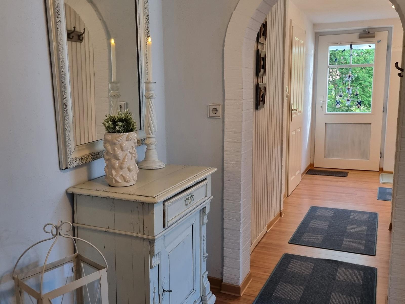 Entrance area with cabinet, mirror, and door to outdoor area.