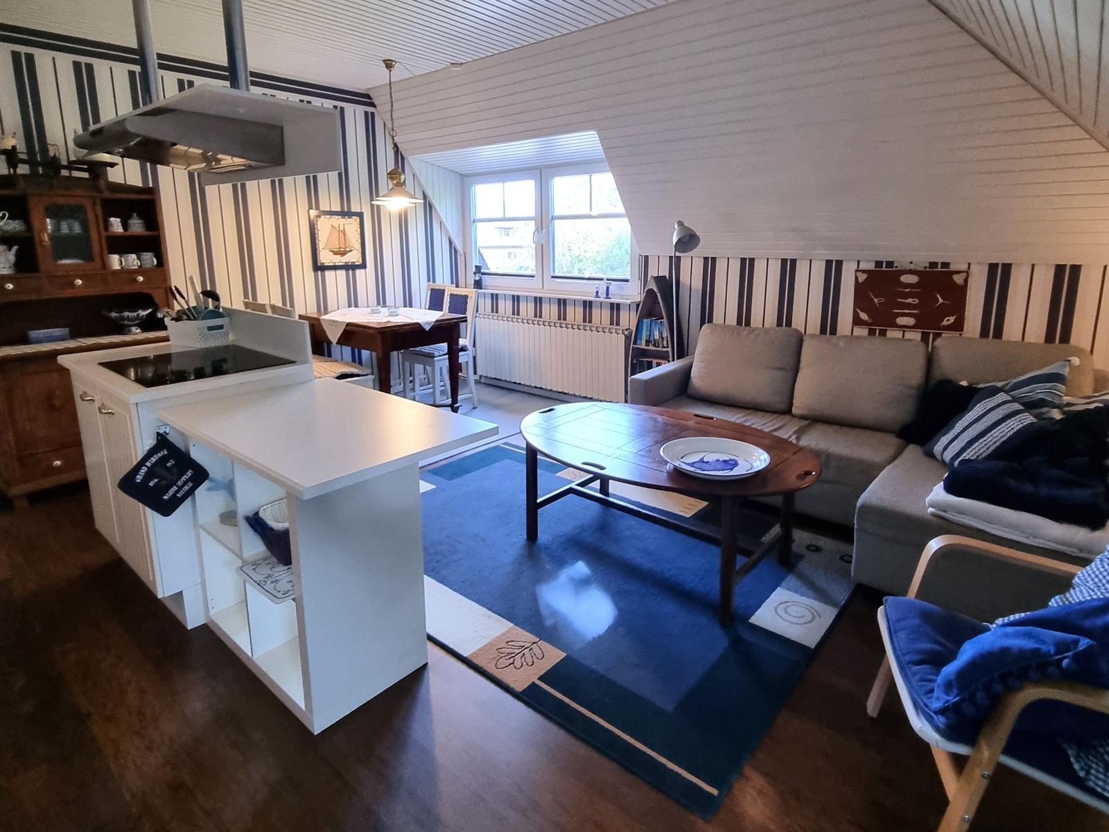Kitchen with dining area and living room with sofa and coffee table.