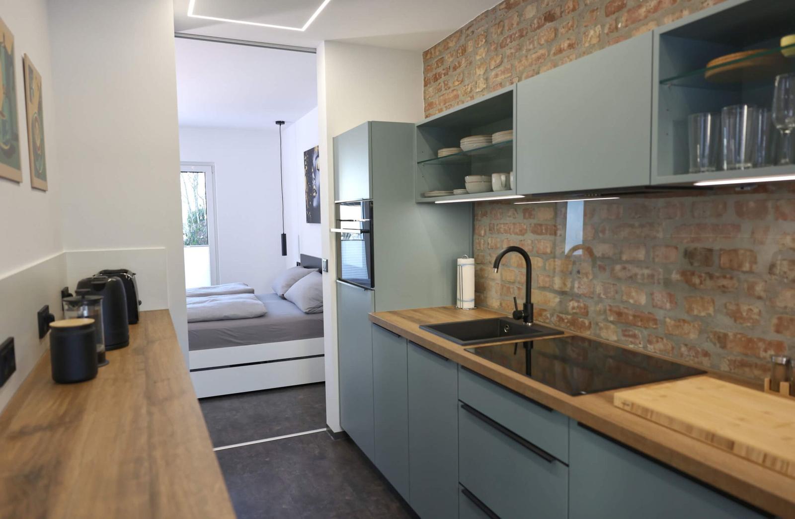 Crafted by a carpenter Kitchenette with a view towards the bedroom and balcony