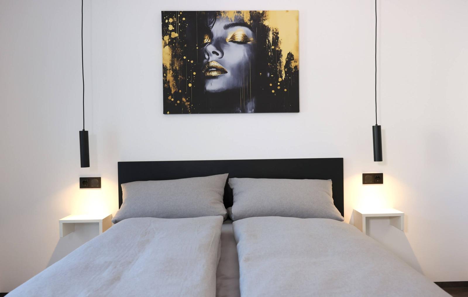 Bedroom with double bed and a beautiful work of art above the bed