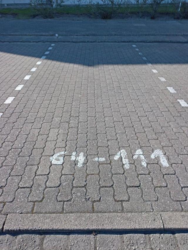 Parkplatz mit weißen Markierungen und der Aufschrift 64-111
